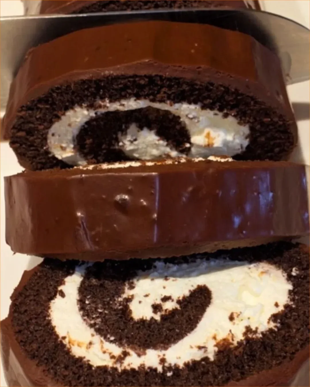 Schokoladenkuchenrolle auf einem Teller mit Schokoladenglasur