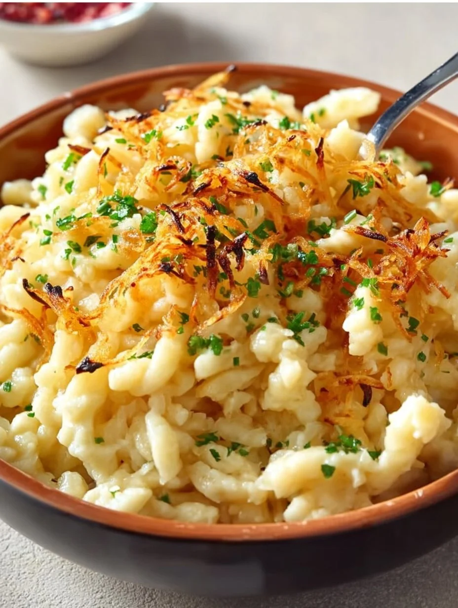 Käsespätzle mit Käse und Zwiebeln, serviert in einer traditionellen deutschen Schüssel.
