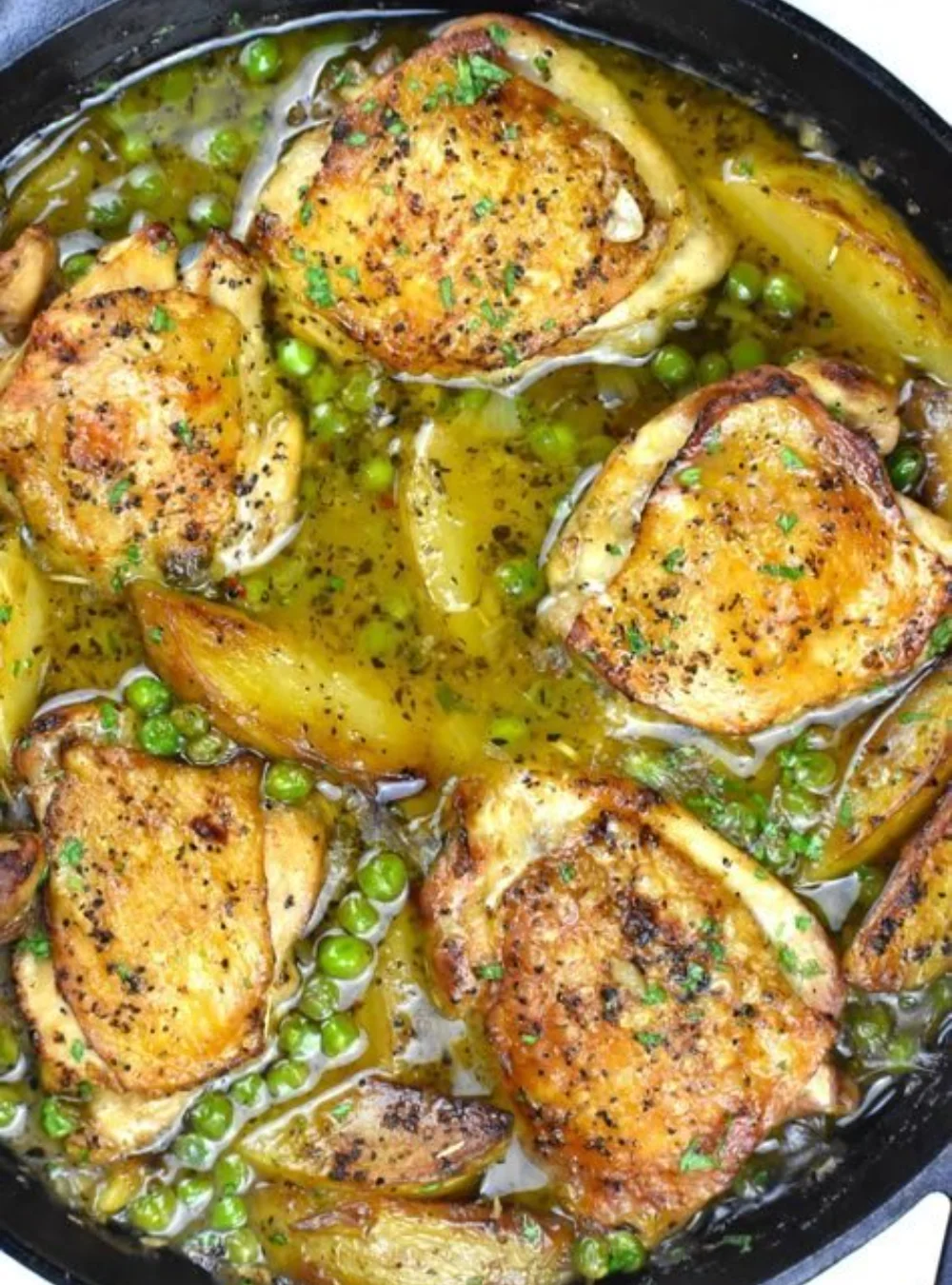 Ein Teller Hühnchen Vesuvio mit frischen Kräutern und Beilagen