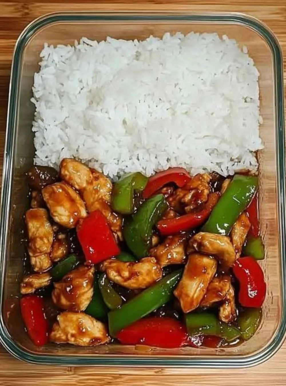 Hähnchen-Paprika-Pfanne mit Reis auf einem Teller, schnell und einfach zubereitet.